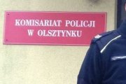 Zdjęcie przedstawia część Komisariatu Policji w Olsztynku oraz fragment policjanta.