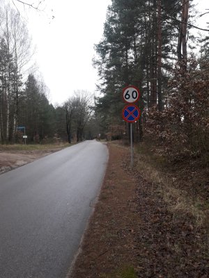 Zdjęcie przedstawia odcinek drogi z oznakowaniem pionowym.