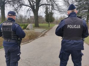 Zdjęcie przedstawia umundurowanych policjantów w parku.
