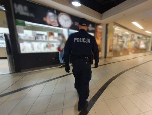 Zdjęcie przedstawia policjanta w galerii handlowej.