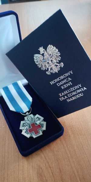 Zdjęcie przedstawia medal &quot;Honorowy Dawca Krwi. Zasłużony dla Zdrowia i Narodu&quot;.