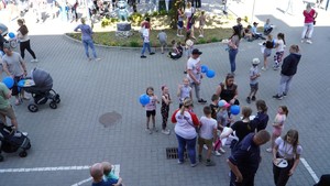 Zdjęcie przedstawia uczestników festynu profilaktycznego.  Na pierwszy planie widać dzieci machające do zdjęcia.