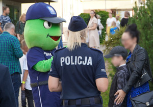 Zdjęcie przedstawia maskotkę &quot;Sierżanta Żabusia&quot; oraz osoby wokoło w tym policjantów.