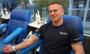 Zdjęcie przedstawia policjanta podczas oddawania krwi.