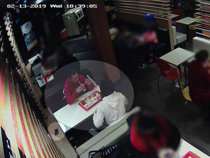 Screen z zapisu monitoringu, osoby siedzące przy stolikach