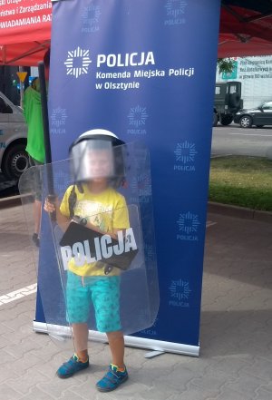 Na zdjęcie znajduje się dziecko z policyjnym  wyposażeniem.
