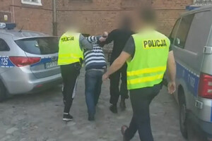 Zdjęcie przedstawia policjantów, którzy prowadzą zatrzymanego.