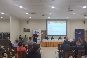 Zdjęcie przedstawia umundurowanych policjantów oraz osoby cywilne uczestniczące w konsultacjach społecznych.