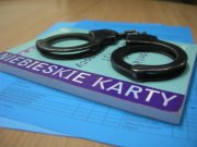 Zdjęcie przedstawia kajdanki oraz Niebieską Kartę