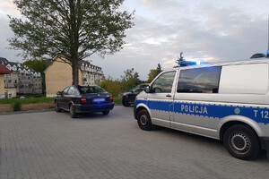 Zdjęcie przedstawia policyjny radiowóz i samochód osobowy.