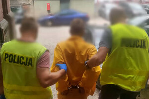 Zdjęcie przedstawia dwóch policjantów i zatrzymanego  mężczyznę.