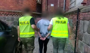 Zdjęcie przedstawia prowadzenie zatrzymanej kobiety.