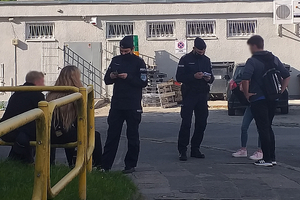 Zdjęcie przedstawia umundurowanych policjantów oraz uczniów przed szkołą.