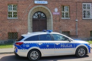 Zdjęcie przedstawia budynek Komisariatu Policji w Dobrym Mieście oraz policyjny radiowóz.