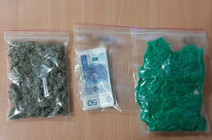 Zdjęcie przedstawia zabezpieczone narkotyki i pieniądze, które leżą na stole.