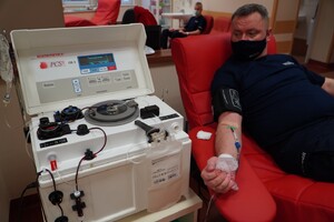 Zdjęcie przedstawia umundurowanego policjanta oddającego osocze.