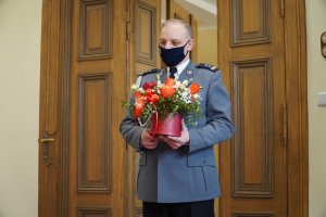 Zdjęcie przedstawia mł. insp. Roberta Zalewskiego trzymającego w ręku kwiaty.