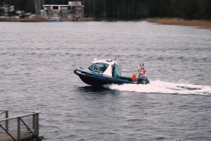 Zdjęcie przedstawia policyjną łódź na jeziorze.