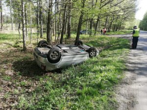 Na zdjęciu widoczny samochód osobowy znajdujący się w przydrożnym rowie. Auto jest przewrócone na dach.