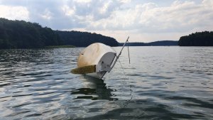 Zdjęcie przedstawia przewróconą łódź.