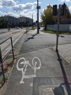 Zdjęcie przedstawia miejsce przejazdu dla roweró. Na przejeździe białą farbą namalowany jest rower.