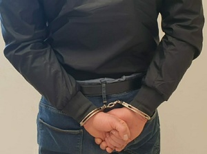 Zdjęcie przedstawia mężczyznę w kajdankach.