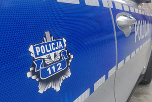 Zdjęcie przedstawia fragment policyjnego radiowozu.