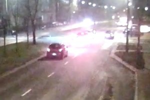 Zdjęcie przedstawia miejsce wypadku drogowego. Na zdjęciu widoczne są auta w rejonie przejścia dla pieszych. Zdjęcie wykonano w porze wieczorowej stąd widoczne są rozbłyski tylnych świateł pojazdów zbliżających się do przejścia dla pieszych.