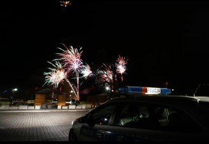 Zdjęcie przedstawia radiowóz a w tle fajerwerki.