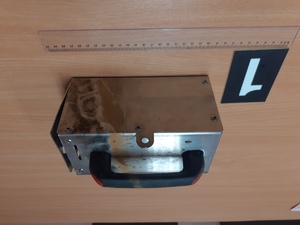 Zdjęcie przedstawia odzyskaną kasetkę na biurku a przed nią linijka oraz obok numer dowodu.