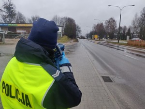 Zdjęcie przedstawia policjantkę wykonującą pomiar prędkości.