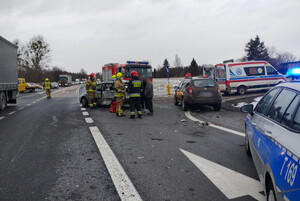 Zdjęcie przedstawia miejsce zdarzenia drogowego na DK 16 - auto uczestniczące w kolizji oraz służby pracujące na miejscu.