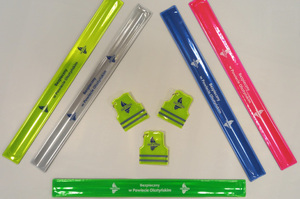 Zdjęcie przedstawia różnokolorowe odblaski z napisami "bezpieczny w powiecie olsztyńskim".