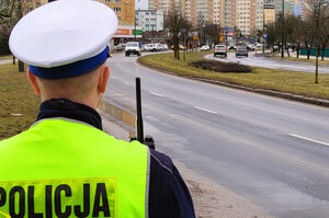 Zdjęcie przedstawia policjanta na ulicy.