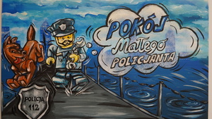 Zdjęcie przedstawia w rysunkowej formie policjanta oraz psa a obok napis Pokój Małego Policjanta.