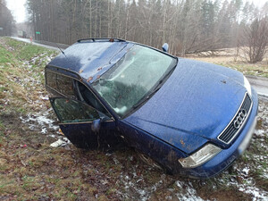 Zdjęcie przedstawia auto w przydrożnym rowie.