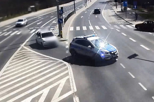 Zdjęcie przedstawia auta na ulicy miasta.