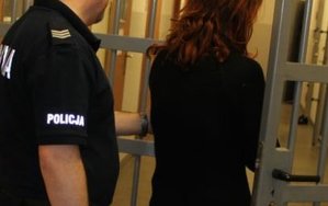 Zdjęcie przedstawia fragment policjanta oraz zatrzymaną kobietę.