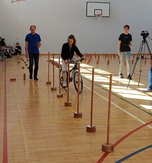 Zdjęcie przedstawia organizatorów oraz uczestników w wieku szkolnym konkursu BRD organizowanego na terenie SP w Barczewie. Zdjęcie wykonano w szkolnej sali sportowej.