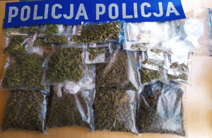 Zdjęcie przedstawia zabezpieczone narkotyki a na górze napis na niebieskim tle &quot;Policja&quot;.