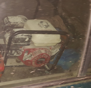 Zdjęcie przedstawia agregat prądotwórczy w bagażniku auta.