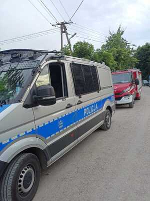 Zdjęcie przedstawia policyjny radiowóz i wóz strażacki.