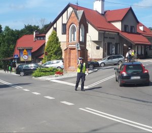 Zdjęcie przedstawia policjanta kierującego ruchem drogowym.