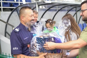 Nadinsp. Tomasz Klimek odbiera wylicytowany kosz z policyjnymi gadżetami