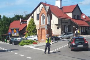 Zabezpieczenie odpustu w Gietrzwałdzie - zdjęcie przedstawia policjantów pracujących przy zabezpieczeniu oraz pielgrzymów biorących udział w pielgrzymce.