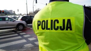 Zdjęcie przedstawia fragment policjanta oraz ruch uliczny.