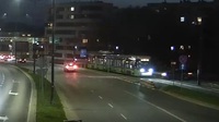 Zdjęcie przedstawia miejsce zdarzenia drogowego. Na zdjęciu widać tramwaj w rejonie stacji paliw. Zdjęcie wykonano w porze wieczorowej.