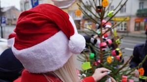 Zdjęcie przedstawia choinkę odblaskową na tle czapki Mikołaja.