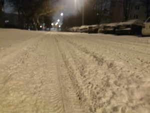 Zdjęcie przedstawia zaśnieżoną ulicę.