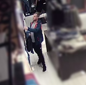 Zdjęcie przedstawia wizerunek mężczyzny w sklepie w związku z kradzieżą.